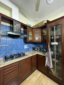 a kitchen with wooden cabinets and blue tiles at HHH Brothers House in Rawalpindi