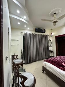 a bedroom with a bed and chairs in a room at HHH Brothers House in Rawalpindi
