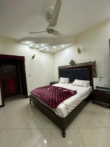 a bedroom with a bed with a ceiling fan at HHH Brothers House in Rawalpindi