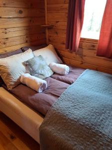 a bed in a log cabin with pillows on it at Kaldbaks-kot cottages in Húsavík