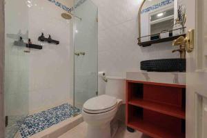 uma casa de banho com um chuveiro, um WC e um lavatório. em LUXURY Mid-Century Apartment In Casco Viejo na Cidade do Panamá