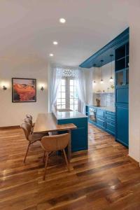 uma cozinha com armários azuis e uma mesa e cadeiras em LUXURY Mid-Century Apartment In Casco Viejo na Cidade do Panamá