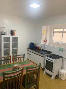 uma cozinha com uma mesa e um fogão forno superior em Apartamento Aconchegante Centro Serra Negra em Serra Negra