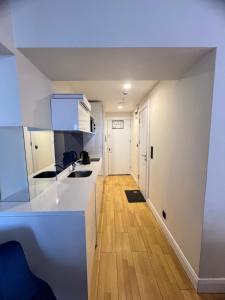 a kitchen with white counters and a wooden floor at Sea views apartments In Batumi in Batumi