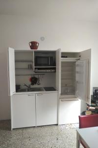 ローマにあるApartment Via Raffaele Balestraのキッチン(白い冷蔵庫、電子レンジ付)