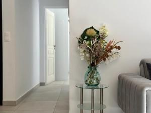 un jarrón de flores sobre una mesa en la sala de estar en P&P - Brand new chic apartments, en Atenas