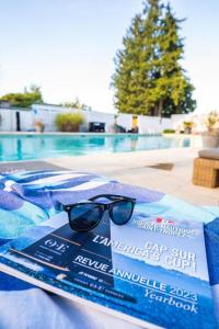 a pair of sunglasses sitting on a towel next to a swimming pool at DOMAINE DE LA SOURCO - Villa, Maisons & Chalet, Magnifique Havre De Paix En Provence in Trans-en-Provence