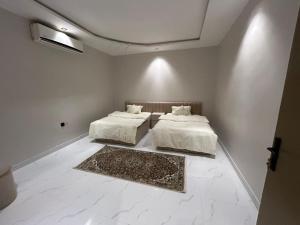 2 łóżka w pokoju z białymi ścianami w obiekcie HAFAL Resort شاليهات هافال w Rijadzie