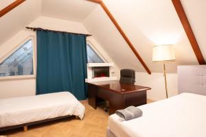 ハンブルクにあるAD Gästezimmer Sinstorfのベッド2台、デスク、窓が備わる客室です。