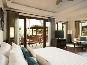 a bedroom with a bed and a television and a patio at Mövenpick Asara Resort & Spa Hua Hin in Hua Hin