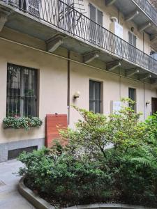 ein Gebäude mit einem Balkon und Pflanzen davor in der Unterkunft [Porta Susa - Centro] Executive Suite x6 con wi-fi in Turin