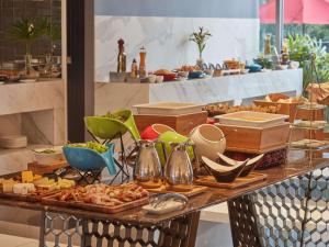un buffet con molti tipi di cibo diversi su un tavolo di Novotel Suites Manila at Acqua a Manila
