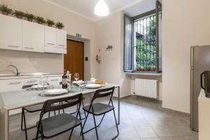 eine Küche mit einem Tisch mit Stühlen und einem Kühlschrank in der Unterkunft [Porta Susa - Centro] Executive Suite x6 con wi-fi in Turin