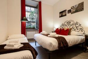 1 Schlafzimmer mit 2 Betten und roten Kissen in der Unterkunft [Porta Susa - Centro] Executive Suite x6 con wi-fi in Turin