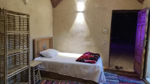 Mezorin Camp في سيوة: غرفة نوم بسرير وغرفة بباب