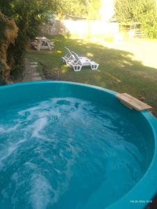 uma grande piscina azul de água num quintal em ammonite aventura del Maipo casa entera reserva 50 por ciento anticipado em San José de Maipo