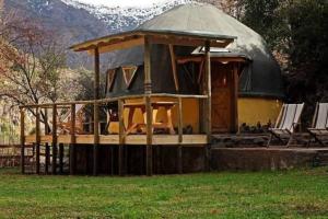 um edifício com um gazebo com cadeiras num campo em ammonite aventura del Maipo casa entera reserva 50 por ciento anticipado em San José de Maipo