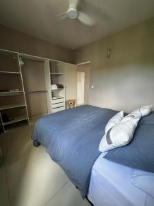 1 dormitorio con cama azul y almohadas blancas en The little Heaven, en Baie Nettle