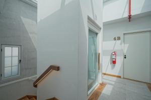 a white hallway with a fire hydrant on the wall at Casa Contemporánea by Wynwood House in Panama City