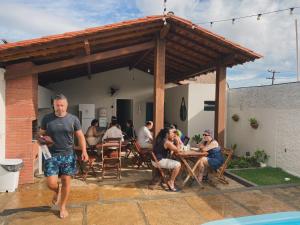 un grupo de personas sentadas en una mesa en un patio en Bangalô Dunas, en Barreirinhas