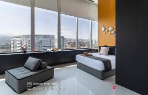 1 dormitorio con 1 cama, 1 silla y ventanas en Kukun Collection, en Ciudad de México