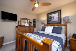 Schlafzimmer mit einem Bett und einem Flachbild-TV in der Unterkunft Lake Front Home 15 Min from BlueRidge Mountains. in Stanardsville