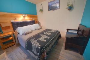 een kleine slaapkamer met een bed en een stoel bij The Secret Garden in Quito