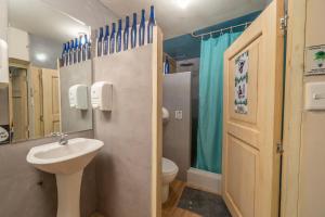 a bathroom with a sink and a toilet and a mirror at The Secret Garden in Quito