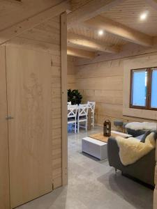 a room with a wooden wall with a couch and a table at Mountain View Chalet with HotTub and Sauna in Czerwienne