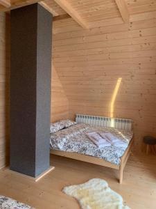 a room with a bed in a wooden cabin at Mountain View Chalet with HotTub and Sauna in Czerwienne