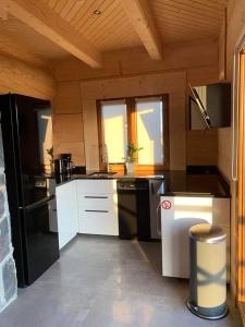 a kitchen with black and white appliances in a cabin at Mountain View Chalet with HotTub and Sauna in Czerwienne