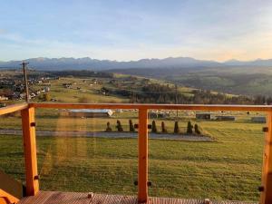 a view of a field from the balcony of a house at Alpine Chalet with Jacuzzi and Sauna in Czerwienne