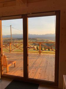 a sliding glass door with a view of a wooden deck at Mountain View Chalet with HotTub and Sauna in Czerwienne