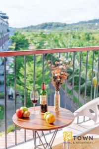a table with a bottle of wine and a glass at Luxy Park Hotel & Apartments - MTown in Phú Quốc