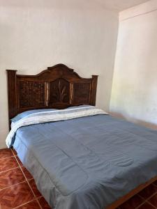a bed with a wooden headboard in a bedroom at Hotel Costa Mar in Troncones