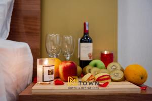 a table with a bottle of wine and fruit and glasses at Luxy Park Hotel & Apartments - MTown in Phu Quoc