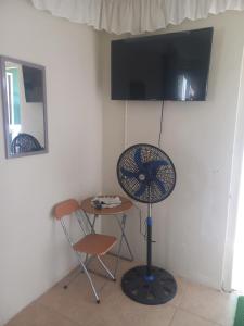 a room with a table and a fan and a chair at Yenna Home in Willemstad