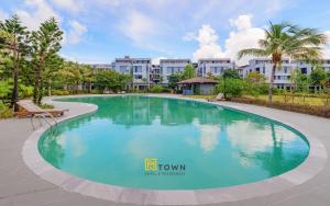 a swimming pool at a resort with buildings in the background at Luxy Park Hotel & Apartments - MTown in Phu Quoc