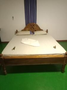 Bett in einem Zimmer mit grünem Boden in der Unterkunft Elephant safari Lodge sigiriya junction in Habarana