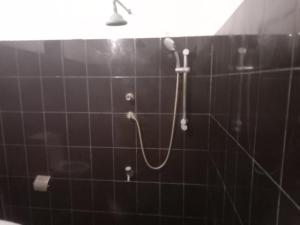 eine Dusche in einem schwarz gefliesten Bad in der Unterkunft Elephant safari Lodge sigiriya junction in Habarana