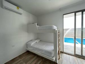 Zimmer mit 2 Etagenbetten und einem Fenster in der Unterkunft Cabaña Cerca Santa Verónica in Juan de Acosta