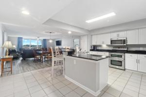 a kitchen with white cabinets and a living room with a table at Yacht Club Villas #2-504 condo in Myrtle Beach