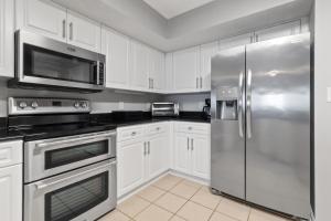 a kitchen with white cabinets and stainless steel appliances at Yacht Club Villas #2-504 condo in Myrtle Beach