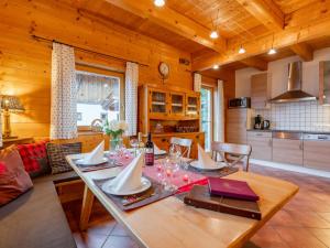 a dining room with a table and a kitchen at Chalet Lisa in Piesendorf