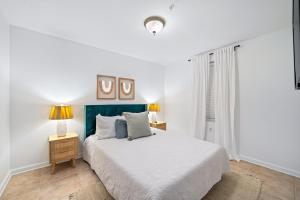 ein weißes Schlafzimmer mit einem Bett und zwei Lampen in der Unterkunft GRANDE CARIBBEAN 414 condo in Orange Beach