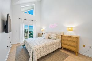 ein Schlafzimmer mit einem Bett, einer Kommode und einem Fenster in der Unterkunft GRANDE CARIBBEAN 414 condo in Orange Beach