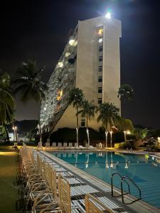 a tall building with a swimming pool at night at Seafront38&39 - Regency Tg Tuan beach resort, port dickson in Port Dickson