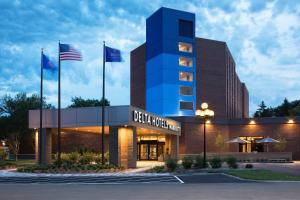 ein Gebäude mit zwei Flaggen davor in der Unterkunft Delta Hotels by Marriott Minneapolis Northeast in Minneapolis