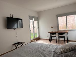Un dormitorio con una cama con un televisor de pantalla plana en la pared. en Exclusiva Casa Sawa, en Barraquero