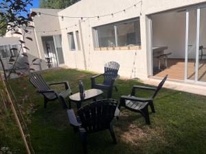 Un grupo de sillas y una mesa en un patio. en Exclusiva Casa Sawa, en Barraquero
